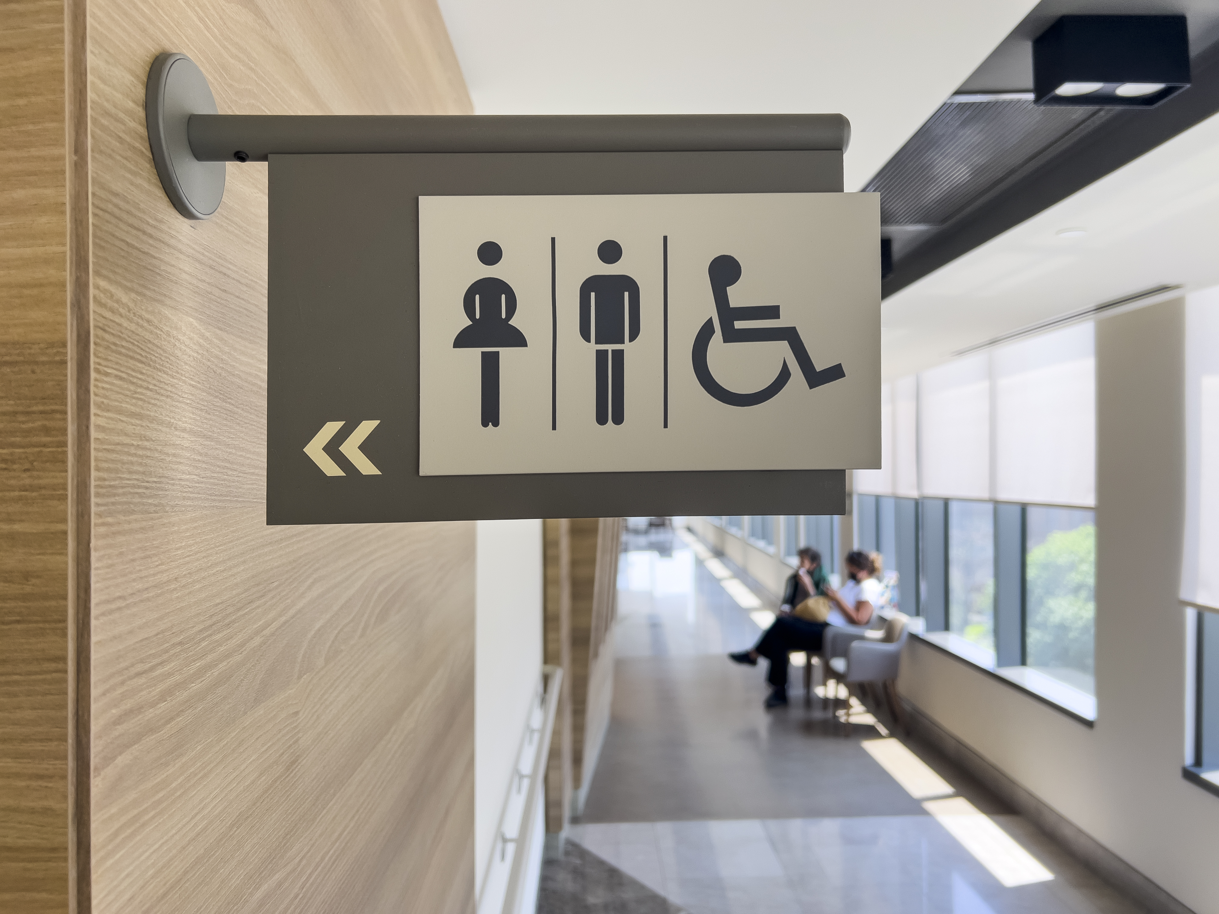 International sign concept: Photography of standard known symbols. Illuminated way guiding sign plate on the wall with copy space.
